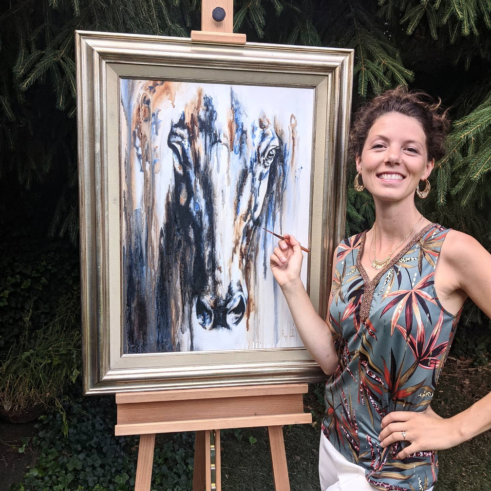 Marjo Lebbe beside a horse painting on an easel
